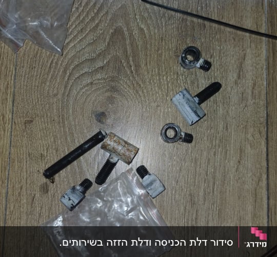 חלקי מתכת וכלים על רצפת עץ